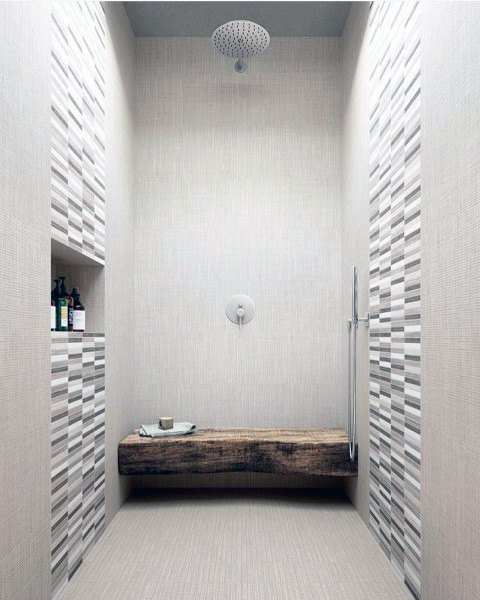 Striped mosaic tile shower walls with a rustic wooden bench and rainfall showerhead.