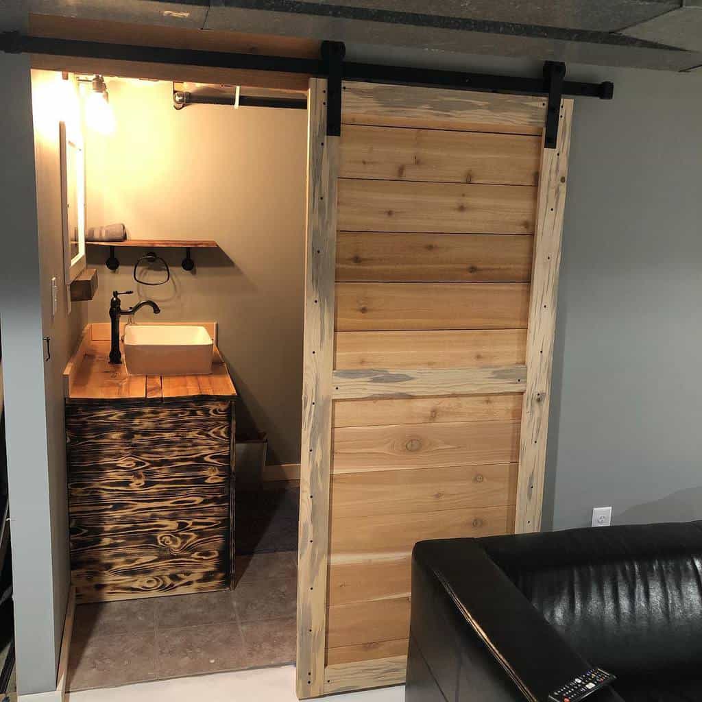 rustic basement bathroom with sliding barn door