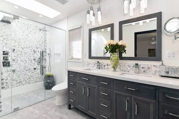 Modern bathroom with double picture-frame mirrors, gray vanity, and glass-enclosed shower.