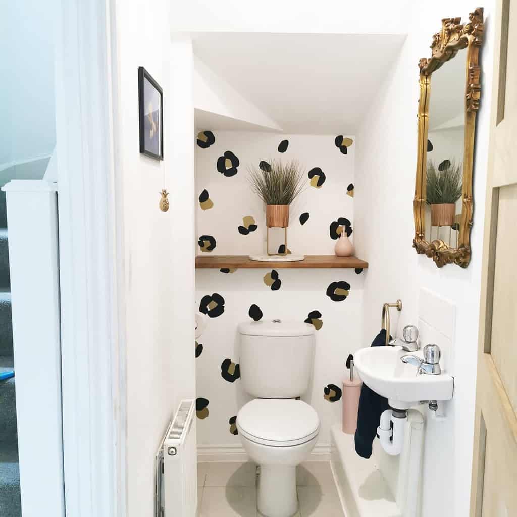print wallpaper toilet with gold framed wall mirror