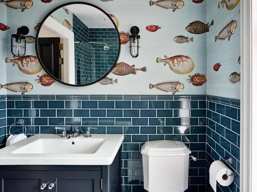 Modern bathroom with fish-themed wallpaper, green subway tiles, and black vanity.