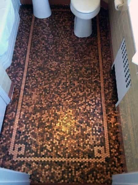 Bathroom with penny tile floor featuring a detailed border and central pattern design.