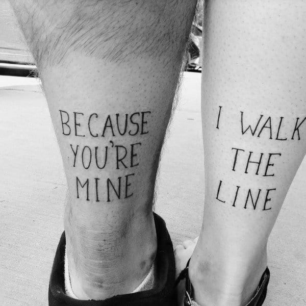 Matching leg tattoos with the phrase "Because you're mine" and "I walk the line," inspired by the classic Johnny Cash song.