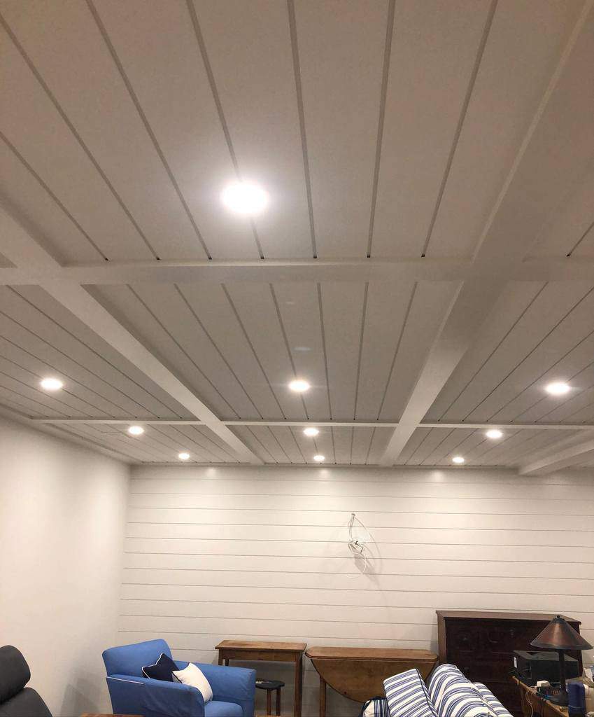 white shiplap walls basement living space