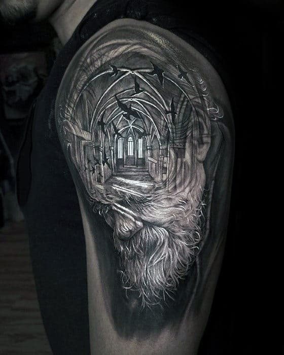 Tattoo of a bearded man's face combined with a gothic cathedral on an arm, featuring arches and birds in grayscale