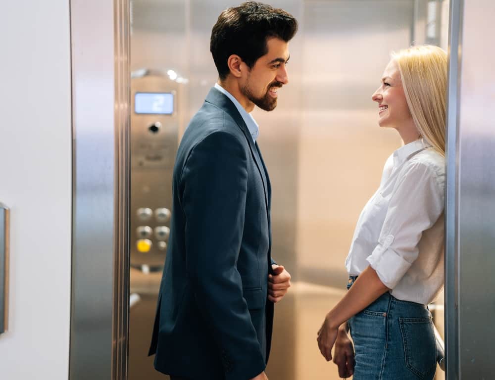 beautiful couple standing inside the elevator smiling each other