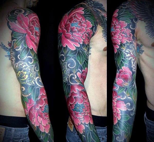 Man's arm tattooed with colorful floral and ornamental designs