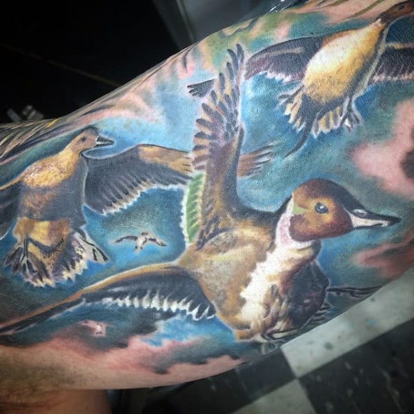Beautiful Tattoo Of Ducks Flying Through Blue Sky On Guy