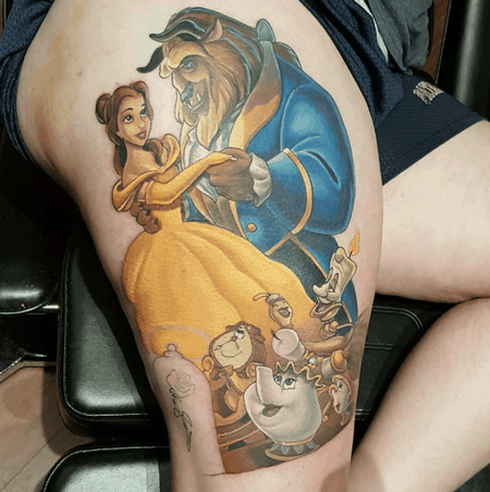 Vibrant thigh tattoo of Belle and the Beast dancing, surrounded by Lumière, Cogsworth, Mrs. Potts, and Chip, in a classic Disney animation style.