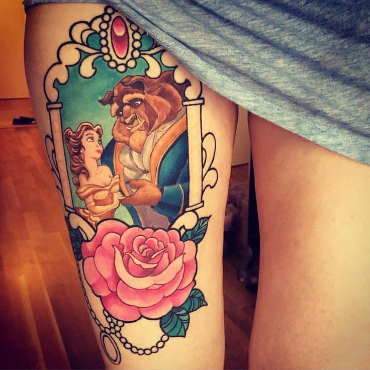 Elegant thigh tattoo of Belle and the Beast framed in an ornate mirror design, with vibrant colors and a detailed pink rose at the bottom.