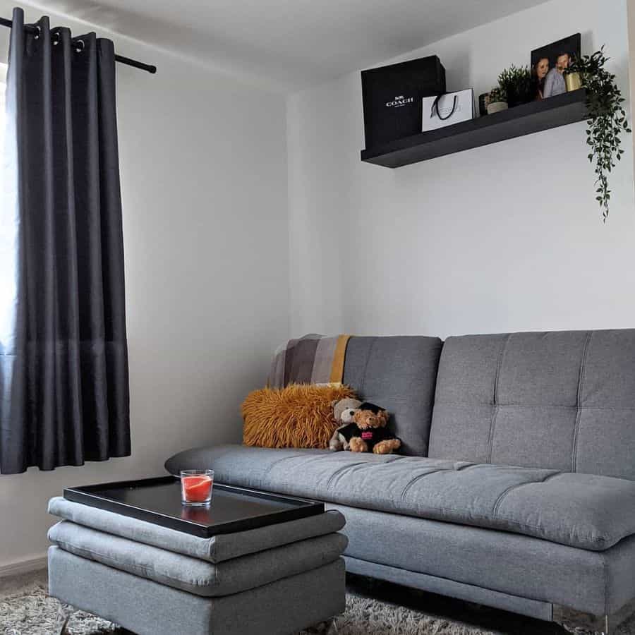 small living room gray sofa bed black wood wall shelf black curtains