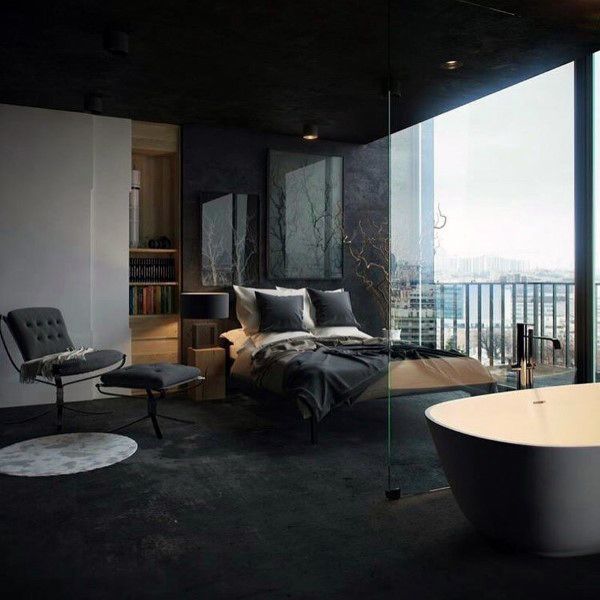 Modern black bedroom with a glass divider, freestanding bathtub, and city skyline views.