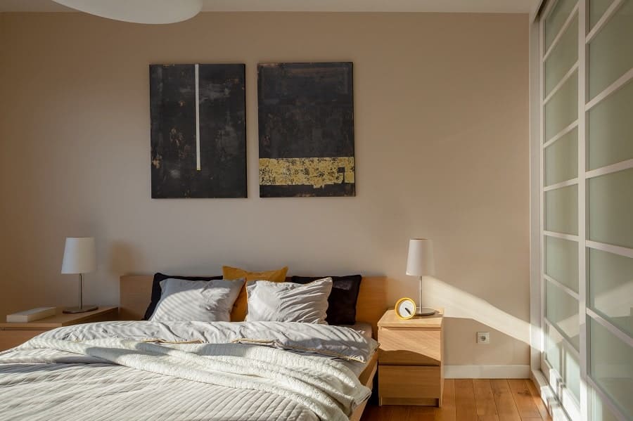 Simple contemporary bedroom with abstract wall art, yellow clock, and sliding closet doors.