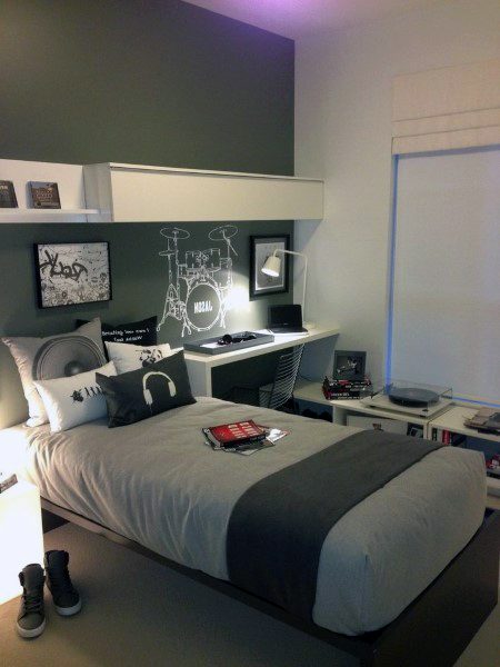 Modern bedroom with a drum set decal, gray and white bedding, shelves, and music-themed decor