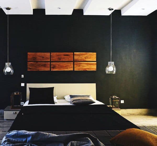 Modern black bedroom with wooden wall art, hanging pendant lights, and minimalist decor.