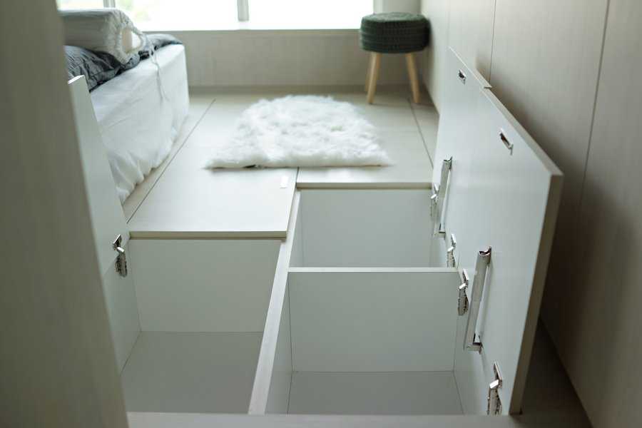 Bedroom with hidden floor storage compartments and cozy decor.