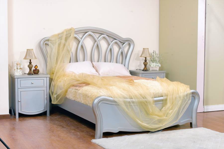 gray bed with intricate headboard 