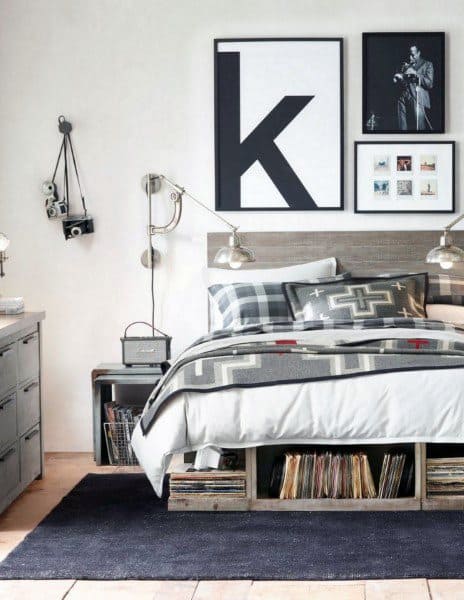 Modern bedroom with a patterned bedspread, wall art, cameras, and vinyl records under the bed