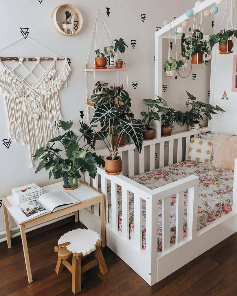 country style kids room white frame bed floral sheets pot plants small desk with sheep seat 