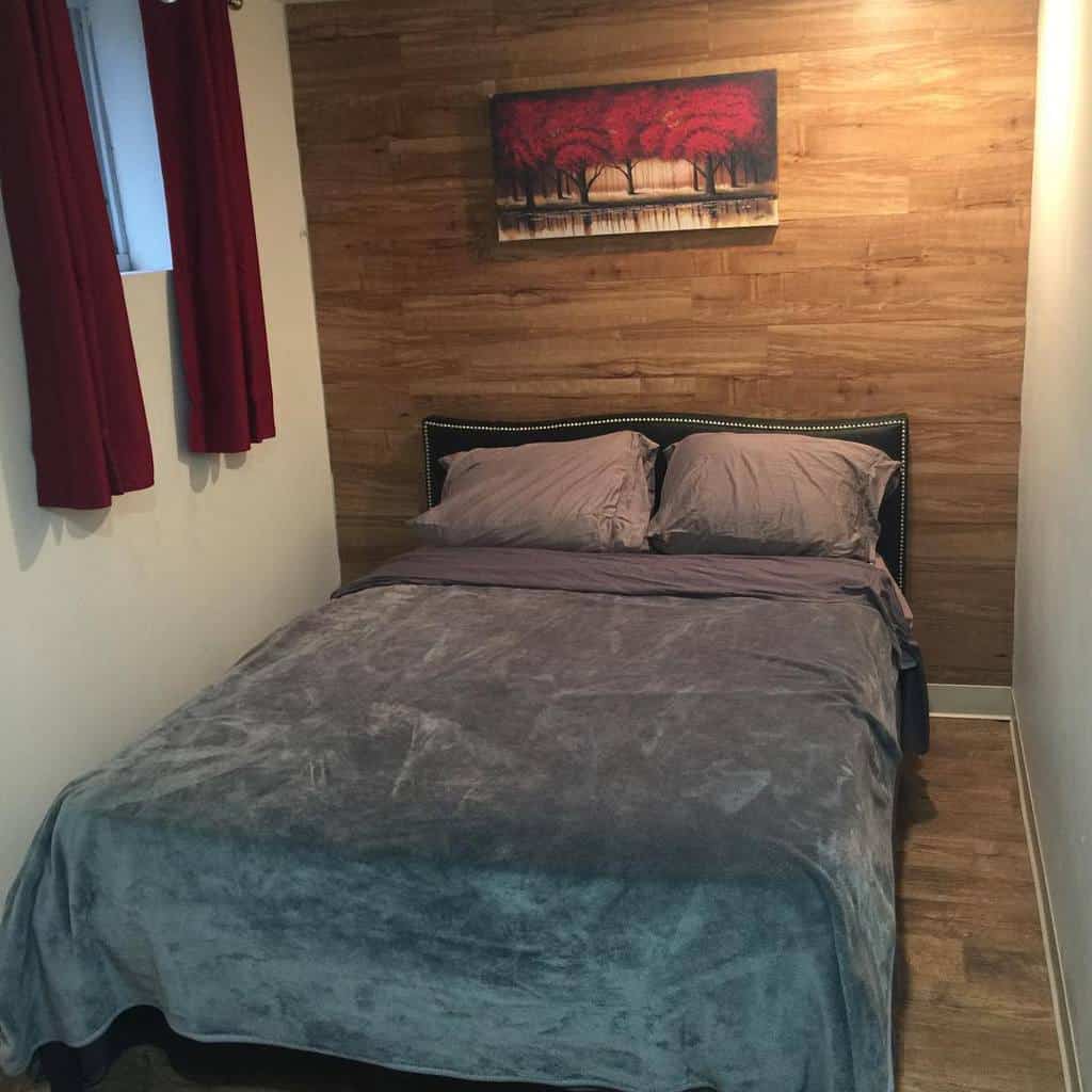 small basement bedroom with wood panel accent wall
