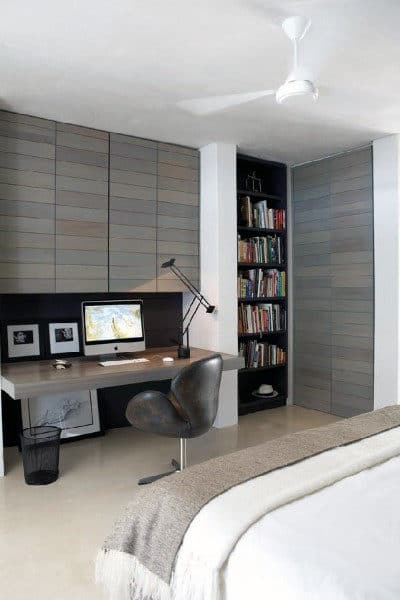 Minimalist bedroom with a corner desk, computer, bookshelf, and neutral tones