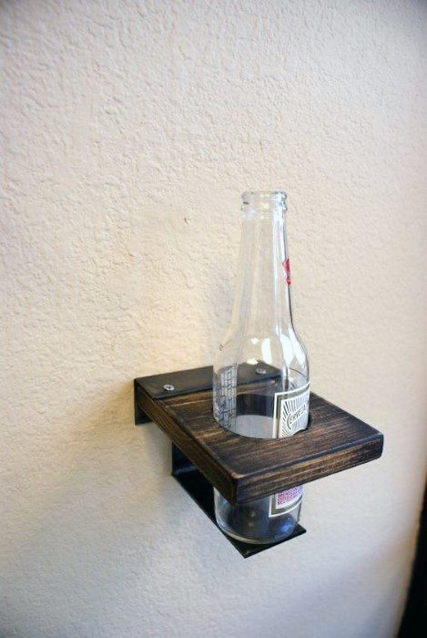 Wooden wall-mounted bottle holder with a glass bottle on it