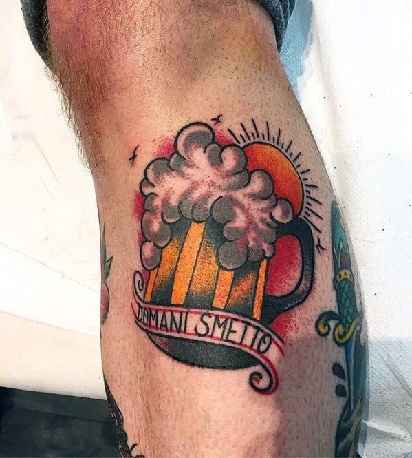 Traditional-style tattoo of a frothy beer mug with a rising sun in the background and a banner that reads "Domani Smetto" (Italian for "I'll quit tomorrow").