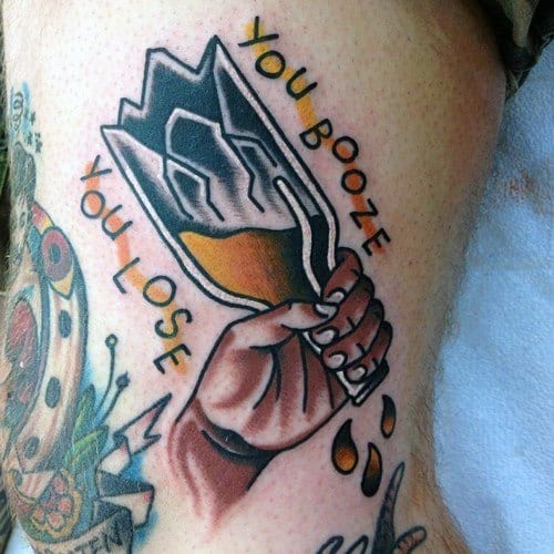 Traditional-style tattoo of a hand gripping a shattered beer bottle with liquid dripping out, framed by the phrase “You Booze You Lose” in bold lettering.