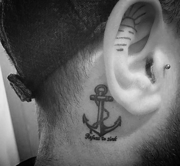 Behind the ear, an anchor tattoo whispers "Refuse To Sink"