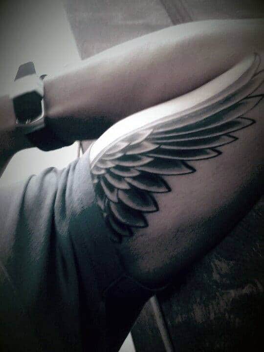 A person with a wing tattoo on their thigh