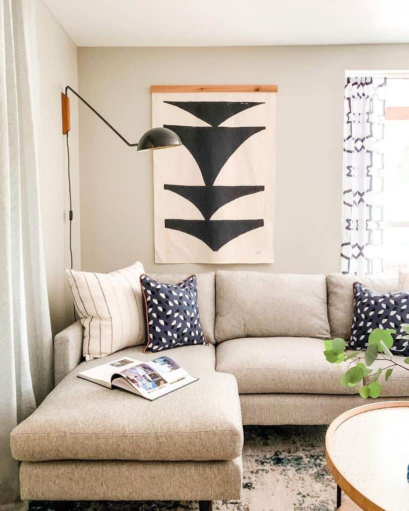 beige living room with gray sofa and wall art