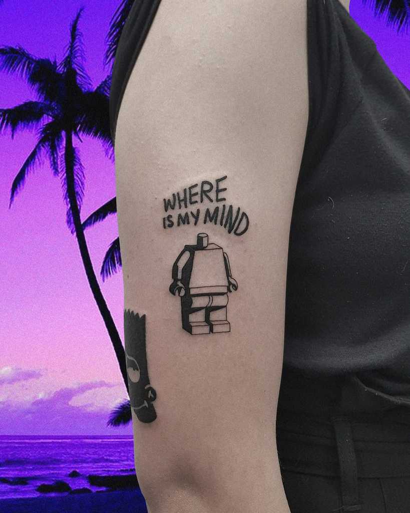 Funny tattoo of a headless LEGO figure with 'Where is my mind' written above. A playful nod to losing one's head—literally and figuratively.