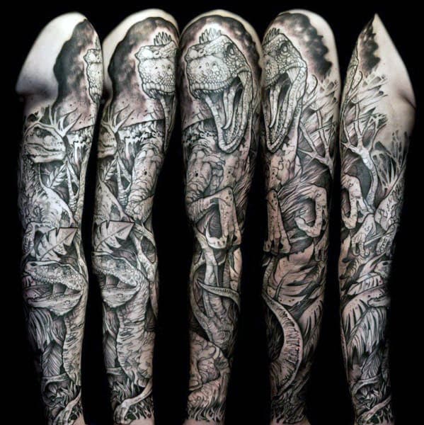Detailed black and gray dinosaur-themed sleeve tattoo covering an arm