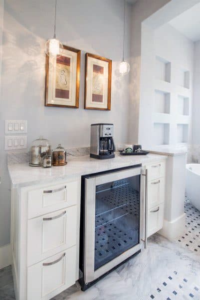 Coffee bar with marble countertop, beverage cooler, coffee machine, and pendant lighting.
