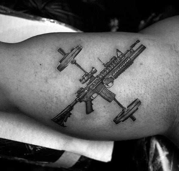 Realistic black and grey tattoo of an AR-15 crossed with a barbell, symbolizing strength, power, and dedication to both firearms and fitness.