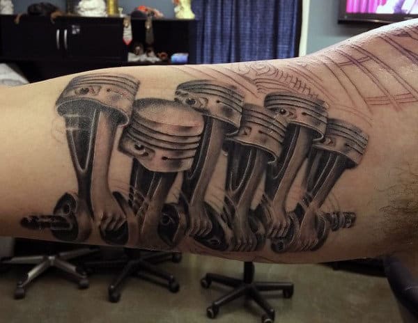 Tattoo of six mechanical pistons on an arm surrounded by shaded and detailed lines