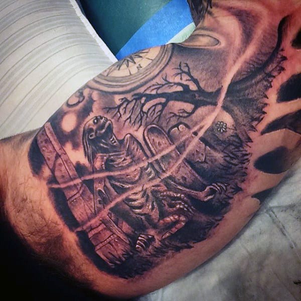 Tattoo of a skeleton sitting against a tree in an eerie graveyard, with a moonlit sky in the background