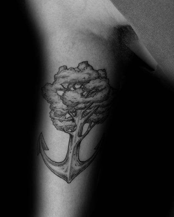 Tattoo of a tree growing from the top of an elaborate anchor