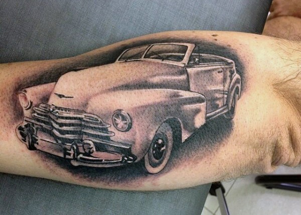 Tattoo of a vintage car with chrome details, inked on an arm, showcasing detailed shading and realistic design