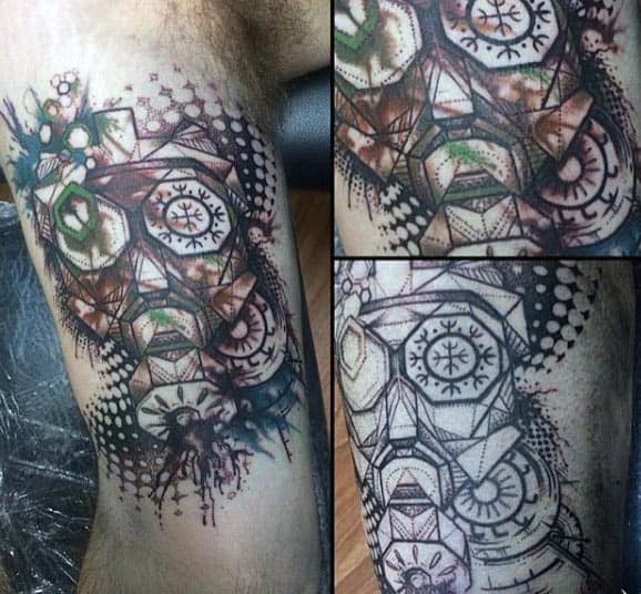 Abstract geometric tattoo with mechanical and tribal elements, featuring bold lines, dot shading, and splashes of color on the bicep