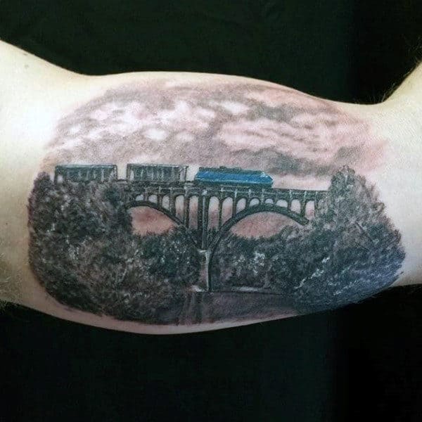 Bicep Train And Bridge Tattoo For Men