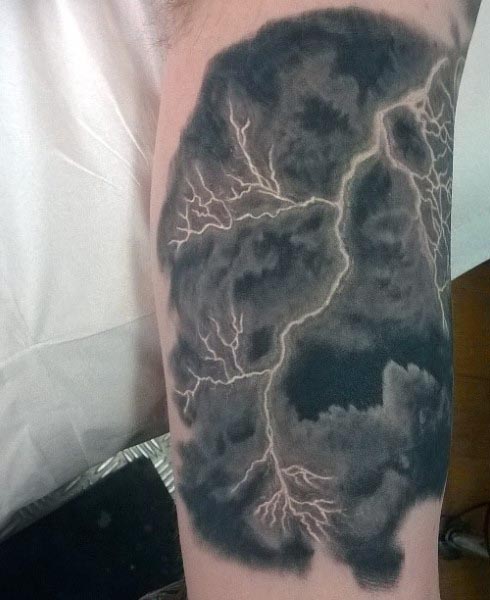 Black and grey tattoo of a stormy cloud with realistic lightning bolts branching across, creating a dramatic and intense design
