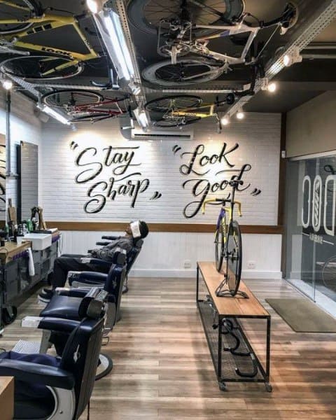 Barbershop with bicycle decor, wooden floors, and motivational wall art saying "Stay Sharp".