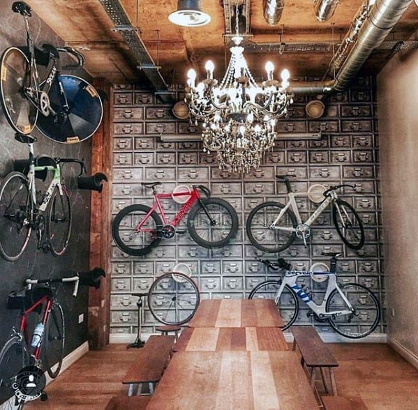 Wall-mounted bicycles with industrial decor and a chandelier in a stylish room.