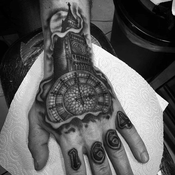 Detailed black and grey tattoo of Big Ben and its clock face on the hand, with the year "1664" inked on the fingers, showcasing intricate shading and depth.