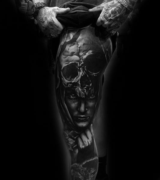 Black and grey leg tattoo featuring a realistic portrait of a woman, a skull overlay, and intense shading for a dark and dramatic design.