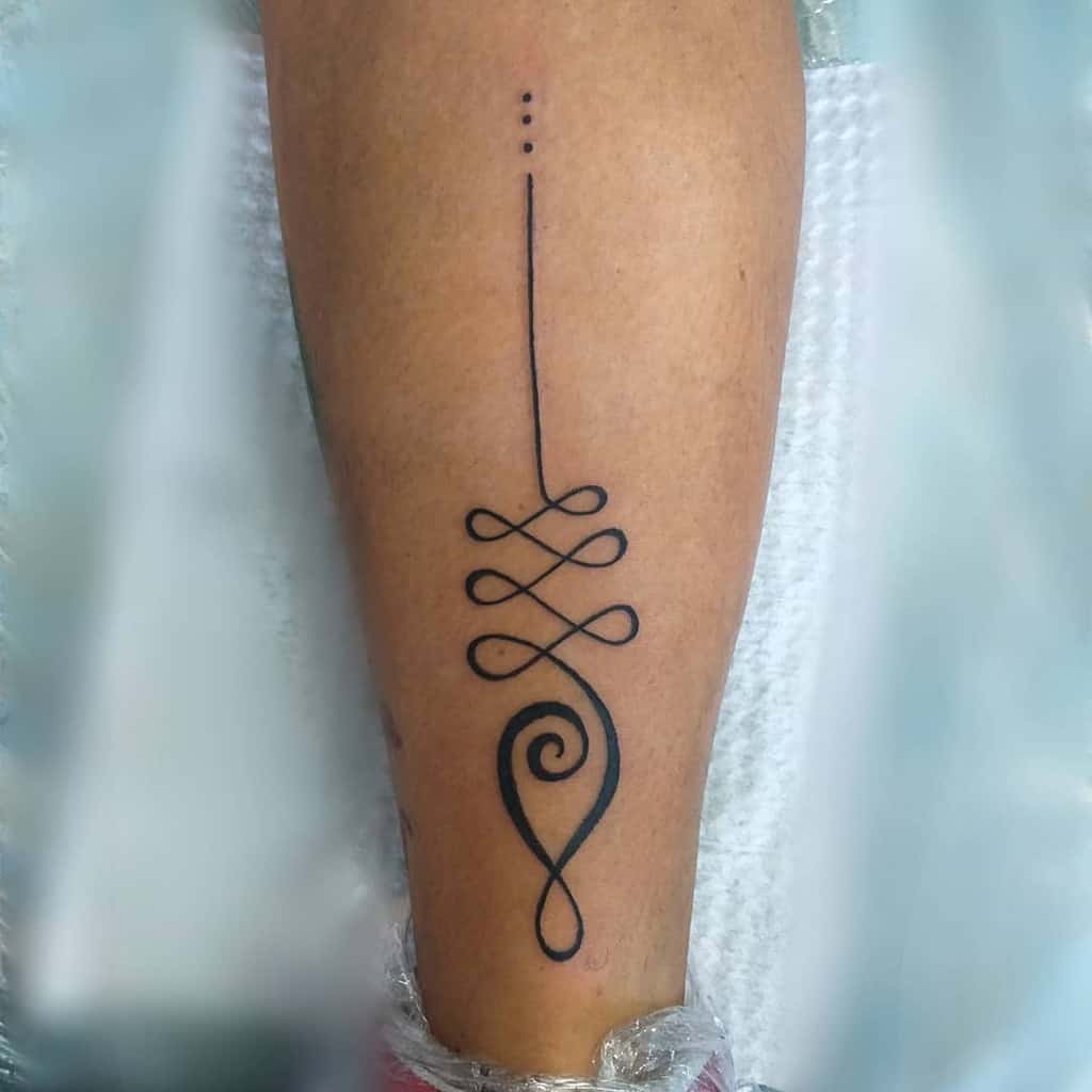 Bold Unalome tattoo on the leg, symbolizing life's journey, personal growth, and the path to spiritual enlightenment and inner peace.