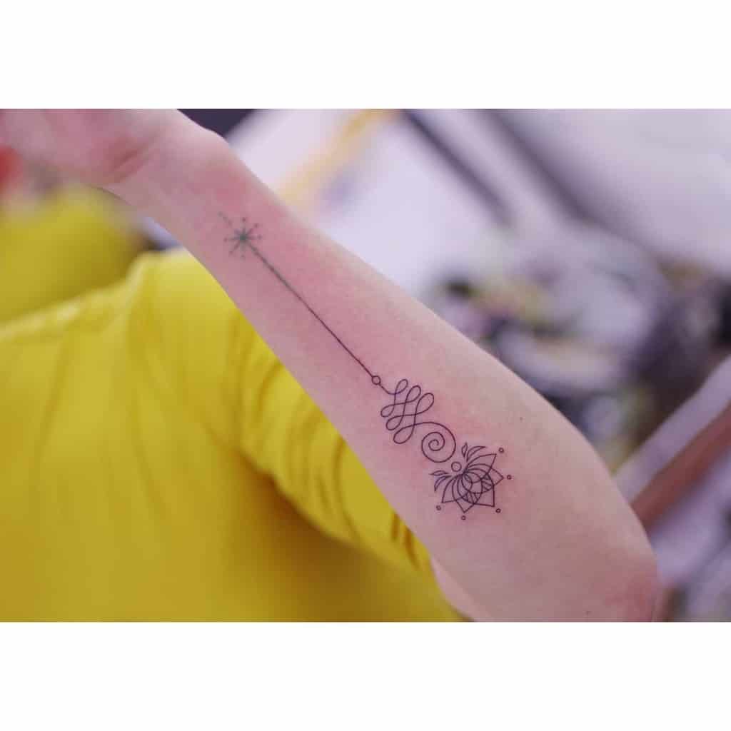 Unalome tattoo with a lotus and star on the forearm, symbolizing spiritual growth, enlightenment, and the journey toward inner balance.