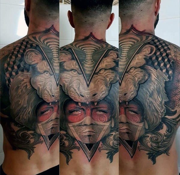 Large back tattoo featuring a fierce lion head, a masked face with red accents, geometric patterns, and ornamental details for a bold design.