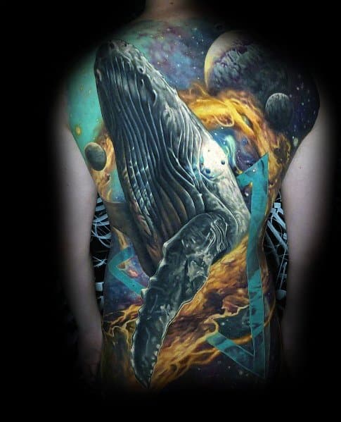 Large full-back tattoo featuring a hyper-realistic whale floating through a cosmic space scene with planets, nebulae, and vibrant fiery elements.